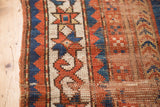 Antique Sewan Caucasian rug's star and crab border in madder red and indigo, showing visible wear.