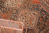 Patinaed madder root red and navy geometric patterns on an antique Qashqai rug.