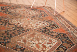 Detailed Qashqai tribal patterns in madder root, navy, and beige, revealing storied antique pile.