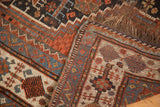 Hand-finished side selvage and woven fringe of the antique Qashqai rug in madder red and blue.
