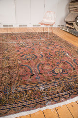 Ornate floral and serrated leaf pattern on dusty blush rose vintage Mahal carpet, with distress.