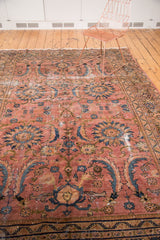 Vintage Mahal carpet detail featuring ornate floral patterns, teal, navy, and gold on a dusty rose field with storied wear.