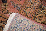Vintage Mahal carpet corner, showing dusty blush rose pile, dark patterns, and tattered fringe.