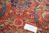 Close-up of vintage Mahal carpet, red field with subtle wear and blue floral patterns.