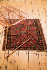 Vintage Lilihan rug's tattered side with cherry red field and floral palmette motifs.