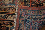 Corner of vintage Mahalati rug, showing intricate floral border and tattered fringe.