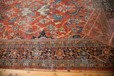 Intricate border and scrolling floral palmettes on a brick red vintage Mahalati carpet.