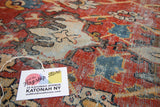 Vintage Mahalati carpet detail revealing foundation wear, brick red, sky blue, and ivory floral pattern.