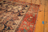 Madder red floral border on an antique Hamadan rug, with indigo and blush boteh field.