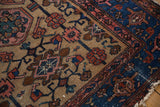 Vintage Hamadan rug detail: indigo border, beige field, geometric florals, worn edge.
