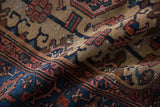 Folded vintage Hamadan rug detail, indigo blue border, beige field, geometric floral motifs.
