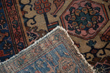 Vintage Hamadan rug corner, showing hand-knotted indigo foundation, blush pile, and frayed fringe.