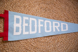 Red side strip and white BEDFORD letters on a baby blue felt pennant.