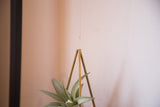 Close-up of the brass Himelli hanger's apex suspended by a thin fishing line.