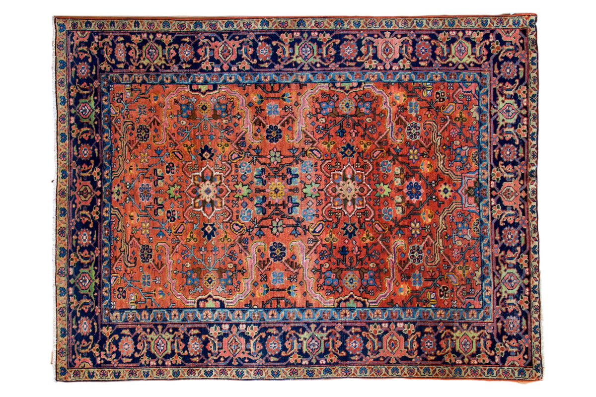 Vintage Heriz rug with peach, madder red, and blue curvilinear serrated leaf design, evenly worn, 4'6" x 6'.