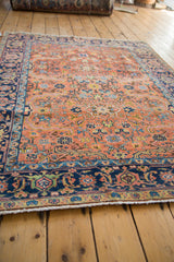 Vintage Heriz rug's curvilinear serrated leaf design on peach field and colorful navy border.