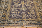 Corner view of a vintage Shirvan rug's intricate star, serpent, and pawn design borders.