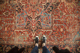 Rich cherry red field of antique Persian Heriz carpet with splayed floral motifs and sky blue vinery.