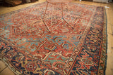 Heriz carpet's intricate splayed floral design and vinery in cherry red, sky blue, and green.