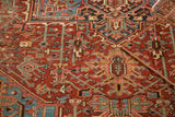 Antique Heriz carpet detail: cherry red field, splayed floral vinery, geometric patterns.
