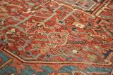 Detail of antique Heriz carpet: cherry red field with sky blue vinery and even wear.