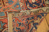 Antique Heriz carpet's folded edge, displaying cherry red, blue patterns and original multi-color selvages.