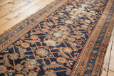 Vintage Hamadan runner: dark indigo field, terra cotta Herati pattern, localized wear.