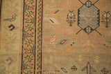 Antique Caucasian runner detail: geometric border in charcoal and pale gold, with a faded bird motif.
