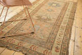 Antique Caucasian runner's end, with tattered finish, geometric border in faded gold, blush tones.