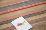 Vintage Turkish Kilim rug with faded red, mauve, peach, and ivory stripes.