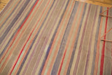 Vintage Kilim carpet with horizontal stripes, showing a small hole and tonal variations.