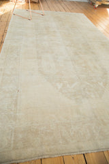 Vintage hand knotted Oushak rug corner, subtle snow white pile, pale beige pattern, and fringe.