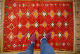 Hand-knotted vintage Moroccan rug's plush pile, with geometric diamond pattern in red, ivory, and tangerine.