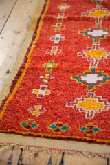 Hand-knotted vintage Moroccan rug with plush pomegranate red pile and geometric diamond motifs.