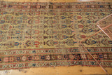Antique Kurdish Bijar rug: pale saffron yellow field, repeating tree motifs, and geometric border.