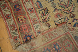 Antique Kurdish Bijar rug's tattered end, showing exposed weave and motifs in madder red and sky blue.