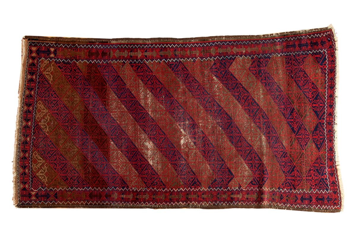 4x7 vintage Belouch rug, diagonal madder red, indigo, camel, gray lattice patterns, with visible foundation wear.