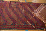 Madder root red and indigo blue geometric patterns with wear on a vintage Belouch rug.