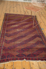 Vintage Belouch rug's red and indigo diagonal bands with intricate lattice motifs.