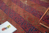 Madder red and indigo blue lattice and panel design on a vintage Belouch rug.