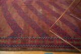 Geometric madder red and indigo border with tattered end on a vintage Belouch rug.