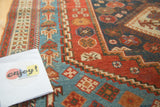 Collectible antique Afshar rug border displaying geometric motifs in pomegranate red and watery blue.