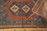 Low pile, geometric indigo field, and pomegranate border of an Antique Afshar rug with worn end.