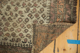Antique Belouch rug detail: ivory field, boteh motifs, visible wear, exposed foundation, tattered selvage.