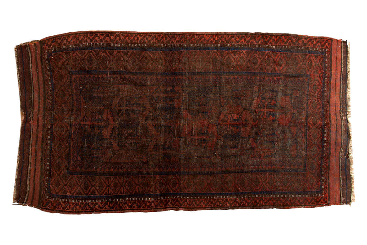 Dramatic vintage hand-knotted Belouch rug, geometric patterns in rich madder red, navy, brown.