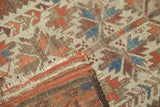 Belouch rug featuring geometric leaf pattern in ivory, red, blue with a tattered end.