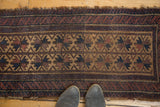 Detail of antique Belouch runner: double starburst motifs, running channels in camel, navy, aubergine.