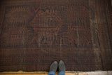Vintage Belouch carpet with faded madder red, charcoal, and navy geometric patterns.