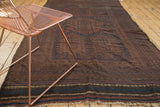 Fringed end of vintage Belouch rug, striped kilim bands, and faded madder red geometric motifs.