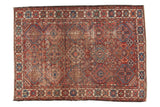 Vintage Baktiari rug featuring geometric diamond patterns, distressed cherry red, blue, and green, 4'8